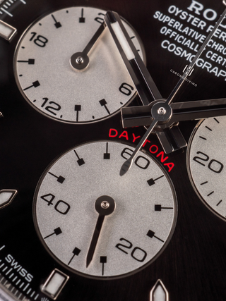 Macro image of the Rolex Daytona 126529LN dial, emphasizing the contrast between the black dial and the silver subdials
