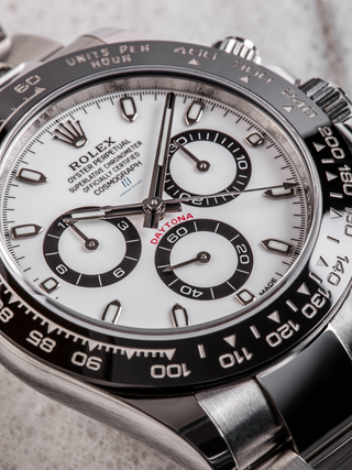 Stainless steel Rolex Daytona 116500LN (Panda) with black subdials, tachymeter bezel (60-400 'UNITS PER HOUR'), full dial text, and angled composition