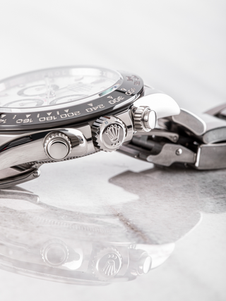 Stainless steel Rolex Daytona with black subdials, tachymeter bezel, visible crown and pushers