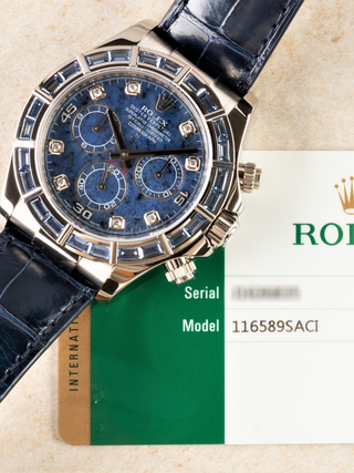 Diamond-set Rolex Daytona 116589SACI with blue dial, baguette-cut diamond bezel, full dial text, and composition with warranty card