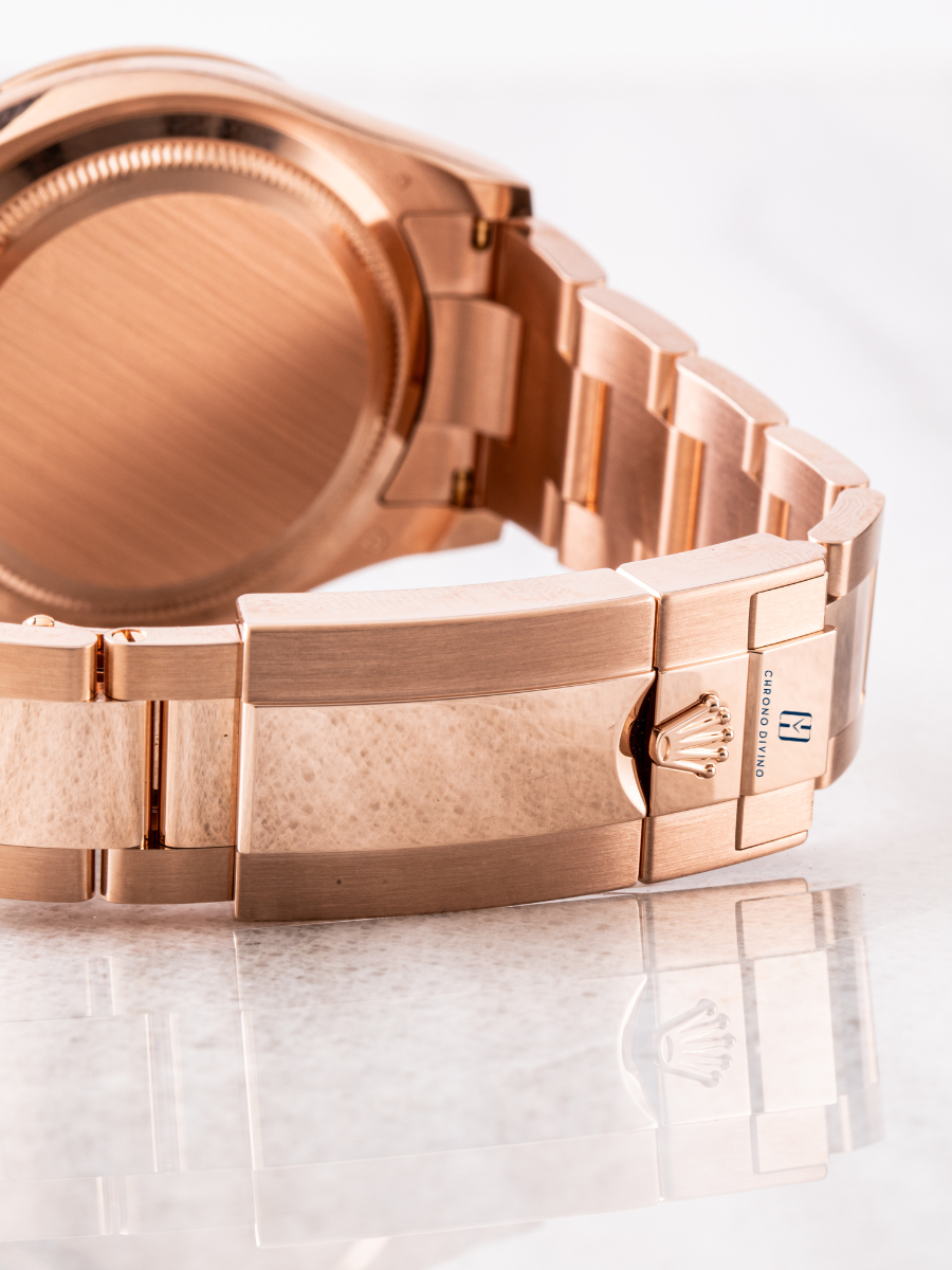 Rolex Daytona 126505 watch in rose gold, showcasing the case back, the rose gold Oyster bracelet, and the deployant clasp reflected on a glossy surface