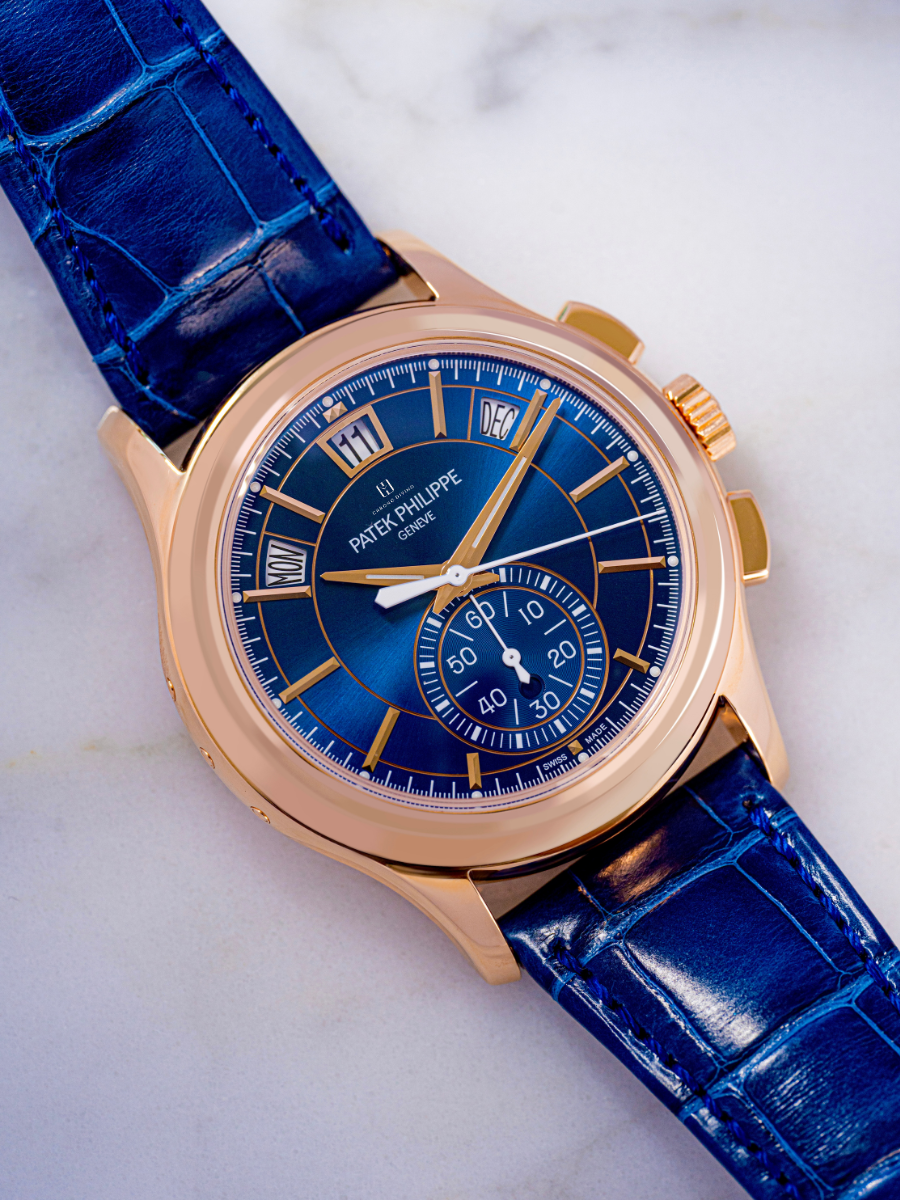 The image is Patek Philippe 5905R-010 in rose gold with a sunburst blue dial, flyback chronograph, and blue strap