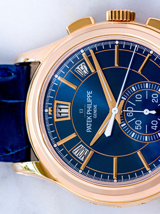 The picture focuses on the left side of blue strap and the portion of the blue dial of Patek Philippe watch