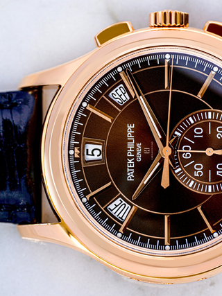 The image focuses on the left side of the blue strap and the portion of the brown dial of Patek Philippe 5905R