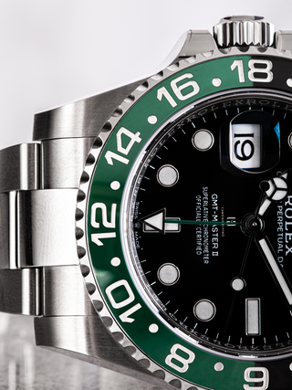 Extreme close-up of the Rolex GMT-Master II 126720VTNR dial, highlighting the luminous hour markers amd Mercedes hands