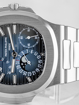Close-up shot of the semi-visible dial of Patek Philippe 5712/1A featuring moon phase indicator and a date display