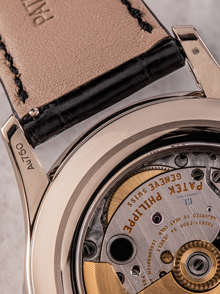 The image shows some portions of Patek Philippe 5205G dial and strap, highlighting Au 750 mark