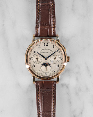 A. Lange & Söhne 1815 Annual Calendar in white gold with silver dial, blued hands, and black leather strap; classic front-facing view.