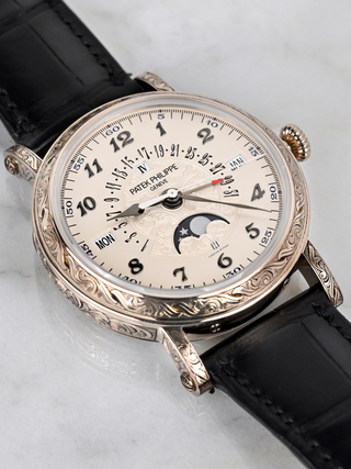 The picture represents Patek Philippe 5160/500G with white gold engraved case, silvery opaline dial, and black alligator strap
