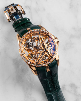 Roger Dubuis Excalibur DBEX0566 in 18k rose gold with diamond-set bezel, silver sunburst dial, and brown leather strap; elegant front view on white background.