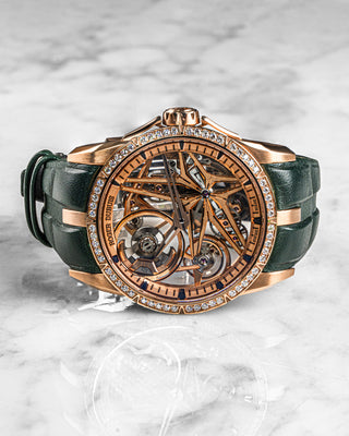 Luxury dress watch by Roger Dubuis – Excalibur DBEX0566 with rose gold case, diamond-set bezel, and silver dial on leather strap.