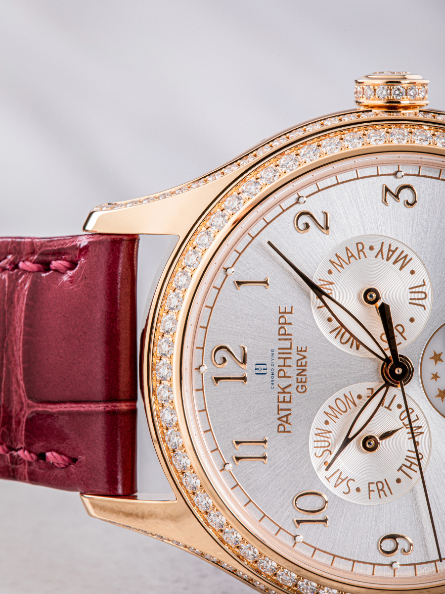 The picture focuses on the brown strap and the portion of  white dial of Patek Philippe watch