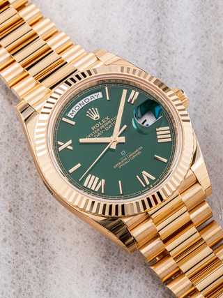 Rolex Day Date 228238 in yellow gold placed diagonally on a textured background