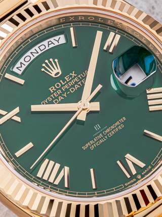 Yellow Gold Rolex Day-Date with green dial, fluted bezel, visible day and date windows