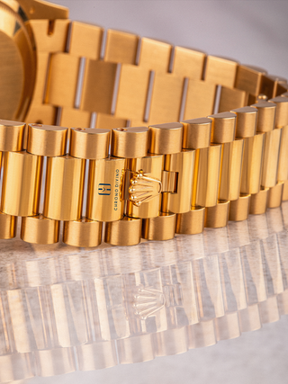 Luxury Rolex Day-Date bracelet with gold links, intricate clasp design, and visible branding