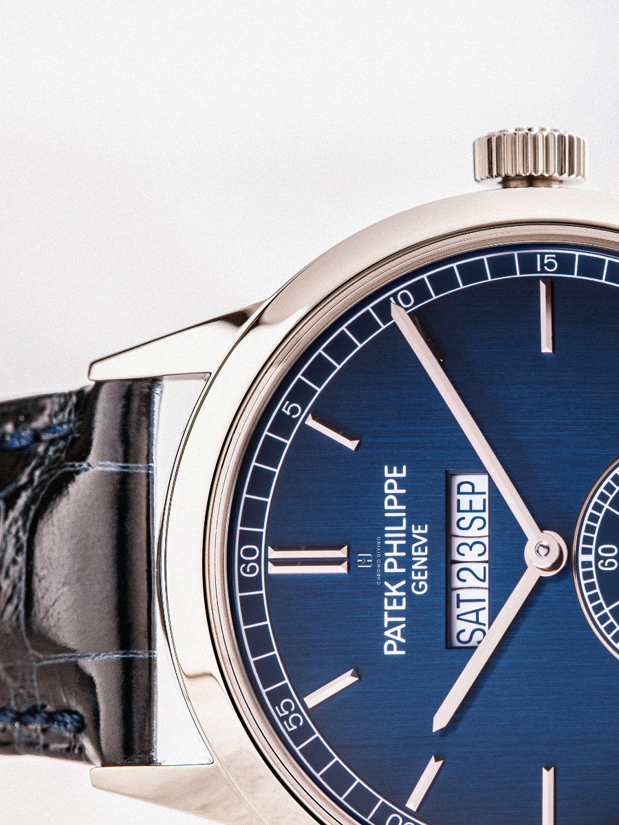 Close-up view of the black leather strap and a glimpse of the blue dial of a Patek Philippe watch is shown