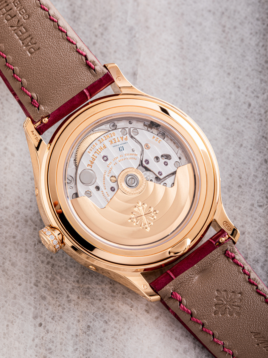 The image is on the right side view of Patek Philippe watch’s  brown strap and the portion of the white dial