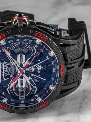 Side-angled shot of Roger Dubuis Excalibur Flyback in titanium, showing off its intricate skeleton dial and bold red-black color scheme.