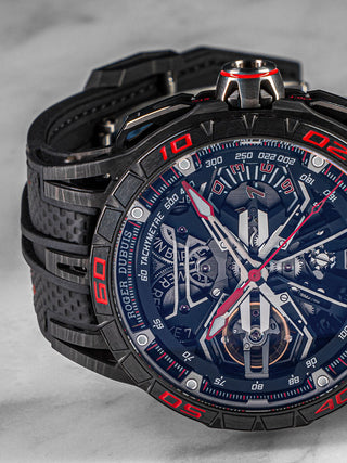 Side-angled shot of Roger Dubuis Excalibur Flyback in titanium, showing off its intricate skeleton dial and bold red-black color scheme.
