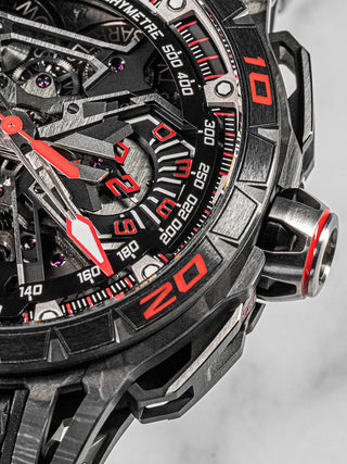Roger Dubuis Excalibur Flyback Chronograph with openworked dial, titanium case, and red-black color palette – precision engineering in a sporty design.